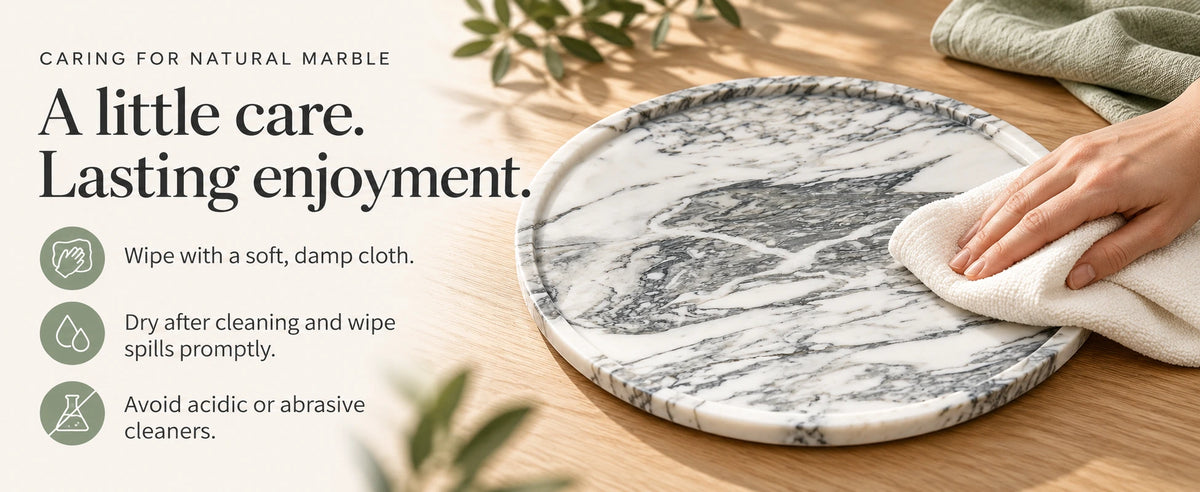 Hand wiping a grey marble round tray with a soft cloth, alongside natural marble cleaning and care instructions.