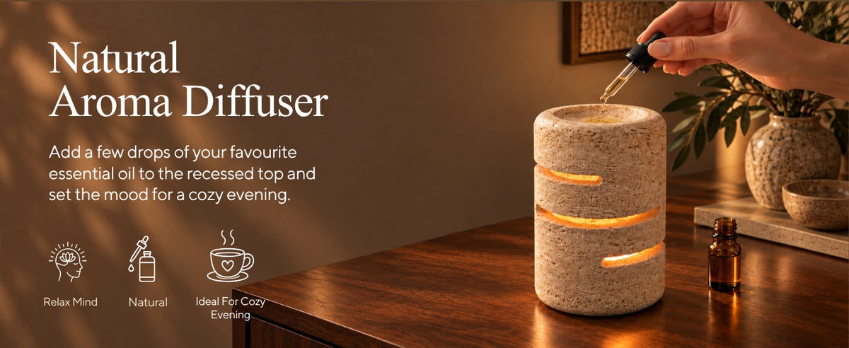 Dropping essential oil into the recessed top of a natural travertine aroma diffuser lamp
