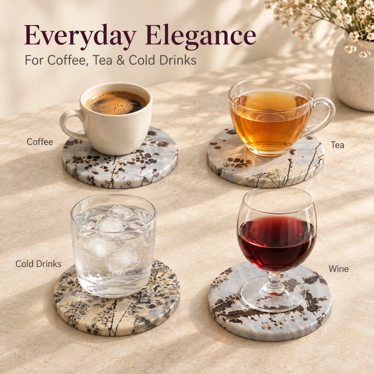 Four Guohua stone coasters holding coffee, tea, iced water and red wine on a light tabletop.