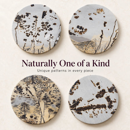 Four round Guohua stone coasters showing individual dark branching patterns on pale grey and cream backgrounds.