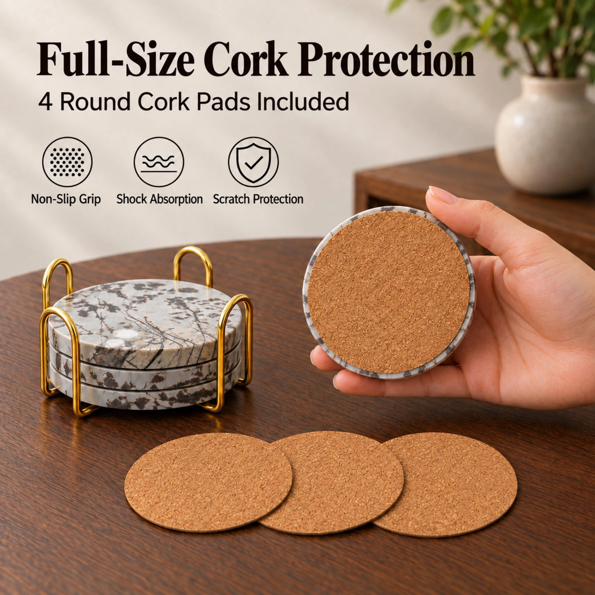 A hand showing the cork backing of a Guohua stone coaster, beside three loose cork pads and a coaster holder.