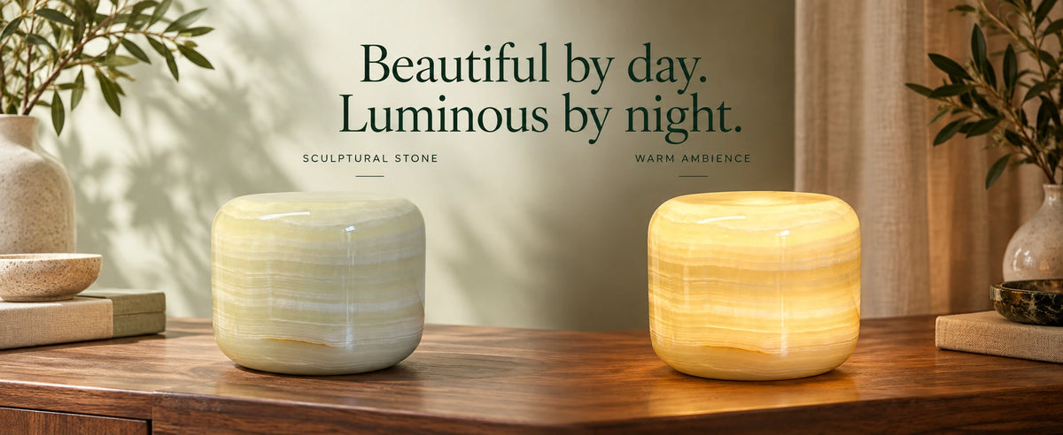Natural marble globe lamp unlit as a stone sculpture by day and glowing warm as ambient light at night