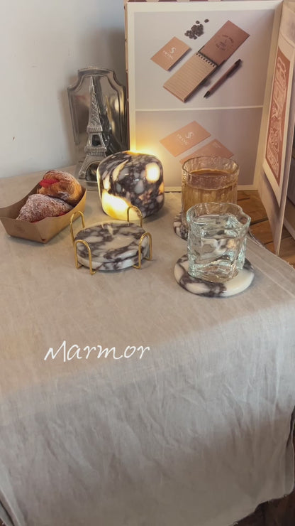 Marmor Calacatta Viola purple marble touch lamp glowing on a linen-covered table with matching marble coasters