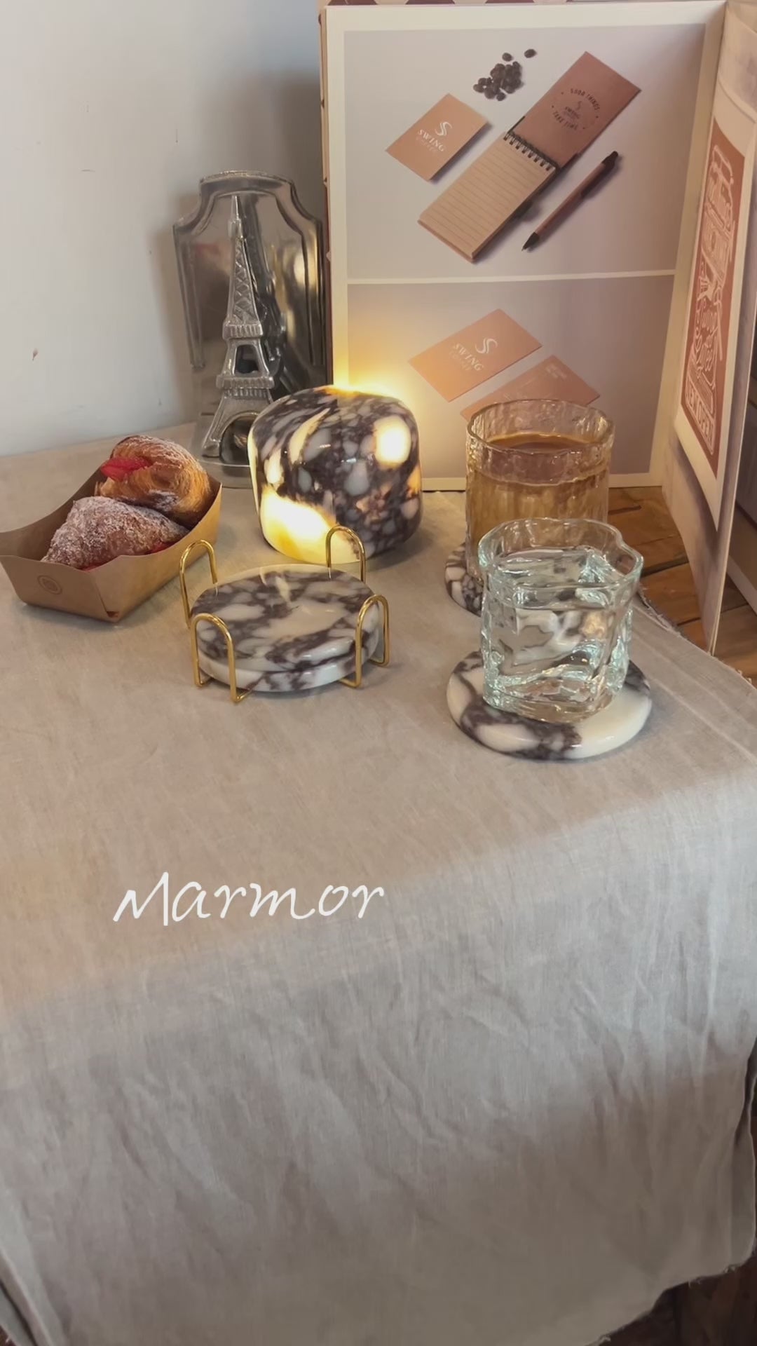 Marmor Calacatta Viola purple marble touch lamp glowing on a linen-covered table with matching marble coasters