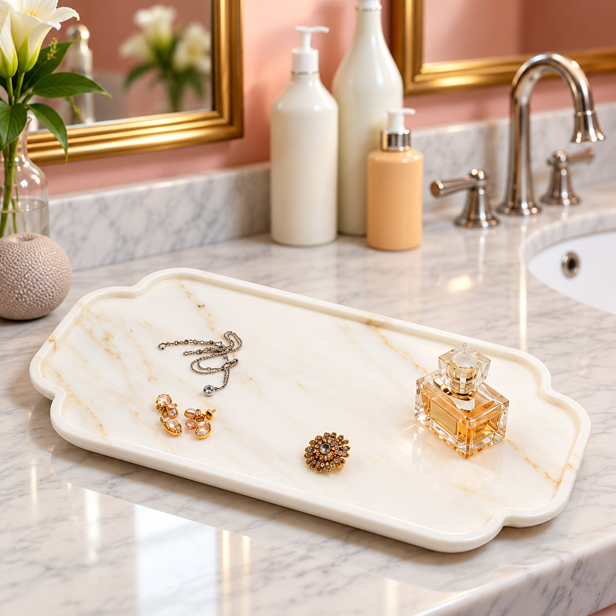 White scalloped marble vanity tray with gold veining, holding jewelry and perfume on bathroom countertop